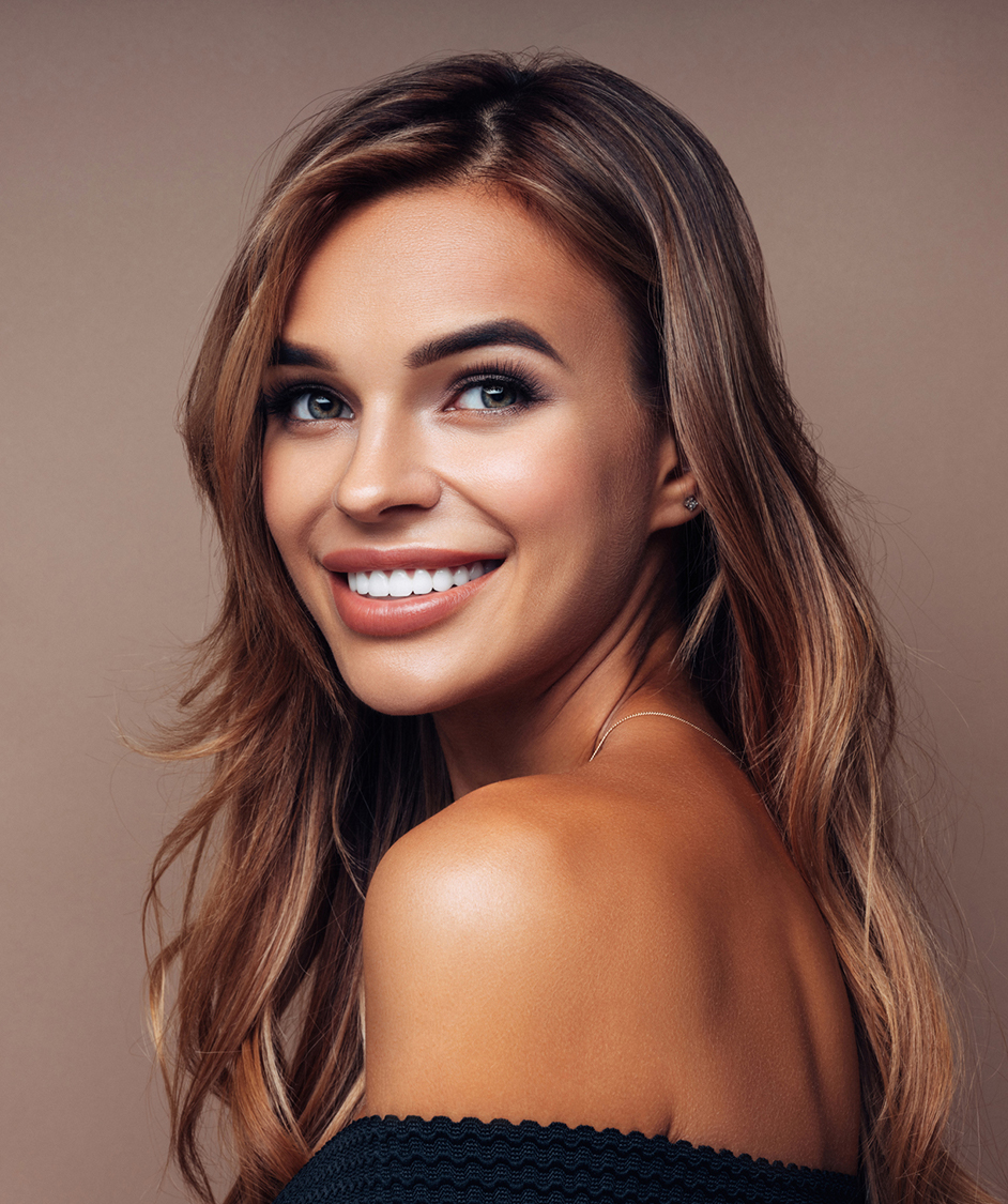smiling woman with long brown hair and black top posing for a picture